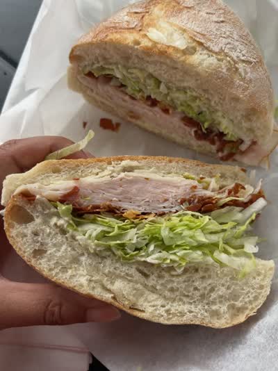 A 10/10 sandwich experience at @tutto.panino — the freshest bun, turkey, shaved parm, iceberg, caesar dressing, and crispy prosciutto 👌🏼